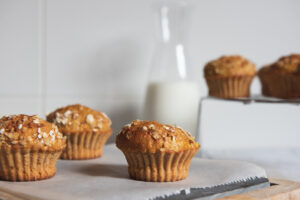 A batch of homemade banana veggie muffins on a rustic wooden table, perfect for healthy snacks or breakfasts, made with wholesome ingredients.